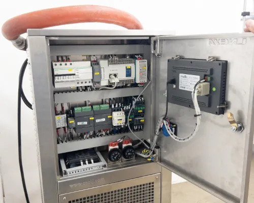 Interior electrical cabinet open showing circuit breakers, contactors, PLC modules, and MagaTPC HMI panel mounted on door interior
