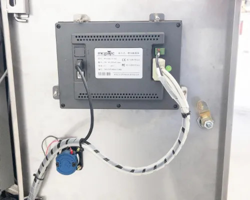 Rear of MagaTPC touchscreen HMI module showing wiring connections, FC and CE certification marks, and fluid fitting at right
