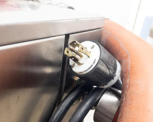 Close-up of NEMA L15-30P twist-lock power plug (208-240V, 30A, 3-phase) with black power cable