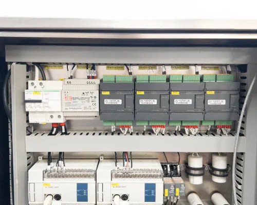Lneya Sundi-225-2TN chiller – internal control panel view showing circuit breakers, DIN-rail mounted PLCs, I/O modules, and wiring