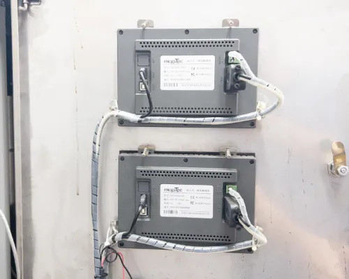 Lneya Sundi-225-2TN chiller – rear of dual MegaTec touchscreen HMI panels showing wiring harnesses and connectors