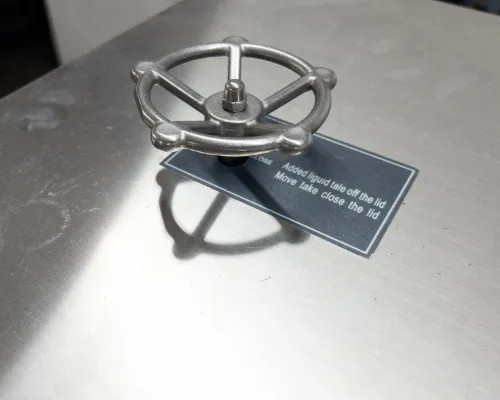 Top surface of Sundi-1A15 showing stainless steel handwheel valve and instructional tag reading 'Added liquid take off the lid, Move lake close the lid'