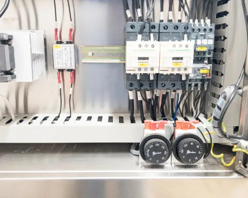 Lower electrical panel interior showing Schneider contactors, Ranco thermostats, terminal blocks, and multi-phase wiring with orange actuator handles