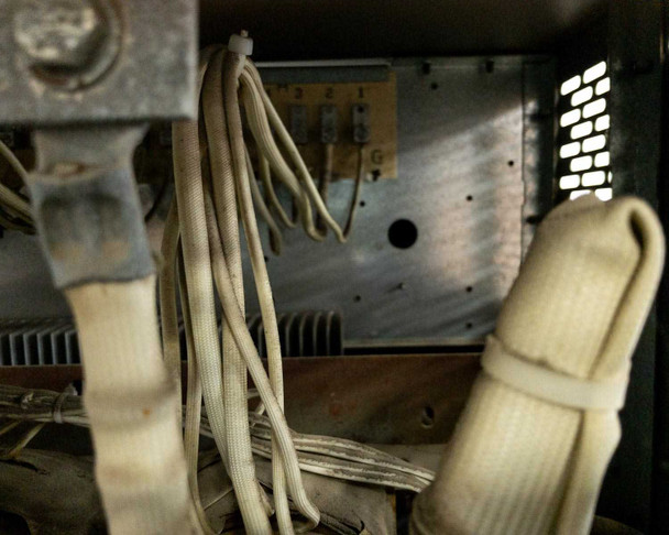 Interior close-up of transformer leads and bundled wiring with ventilation slots in background