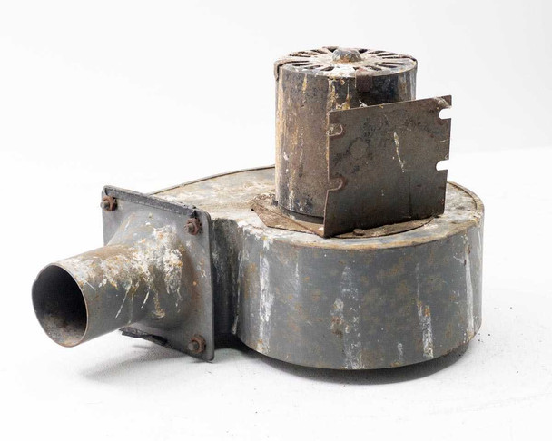 Torrington Electric centrifugal air blower — three-quarter front view showing round steel housing, cylindrical motor on top with open ventilation slots, and square-flanged round tube outlet on left side; heavy surface rust and paint loss throughout