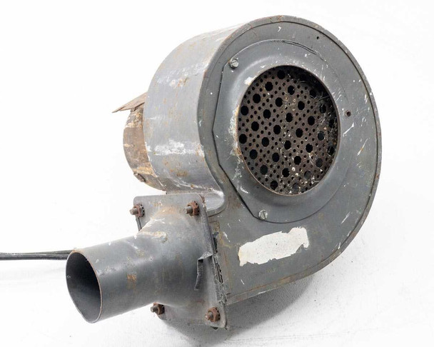 Torrington Electric blower — opposite side view of round housing face with perforated inlet grille, tube outlet visible, power cord trailing from motor; overall paint wear and surface corrosion visible