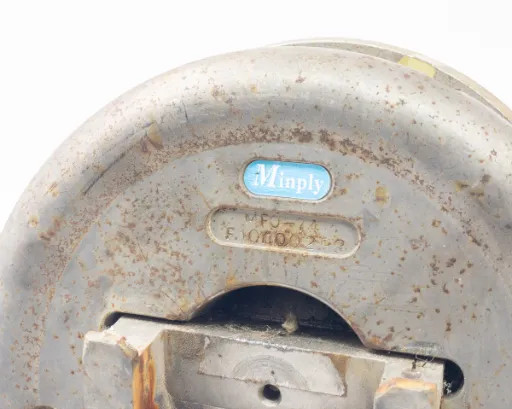 Minply MFO-74 safety chuck – top-down flange face close-up showing blue Minply oval label and model markings with surface rust