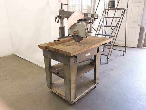DeWalt 7790 radial arm saw full machine on stand with blade guard raised – warehouse floor view