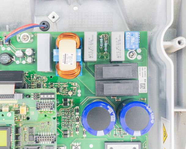 SMA SB3000US internal board — close-up of toroidal copper inductor, relay block, and large filter capacitors in AC output section