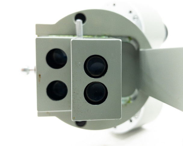 Bottom view of the dual objective turret showing all four objective lens apertures on the 2x/4x turret block
