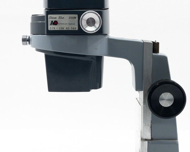 Close-up of AO 569 Stereo Star Zoom body showing 'Stereo Star Zoom' label, AO logo, 0.7X–3.0X range marking, and focus knob on arm