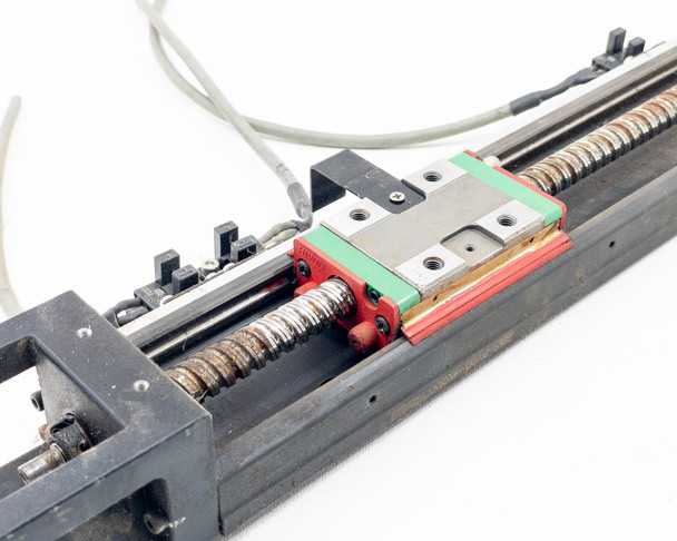 Hiwin KK60 ball screw carriage block close-up showing green and red guideway rail with mounting screws