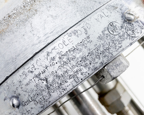 Kiely Mueller PD47S0160-039 nameplate close-up – stamped identification plate with part number, serial number, and Martin purchase order details