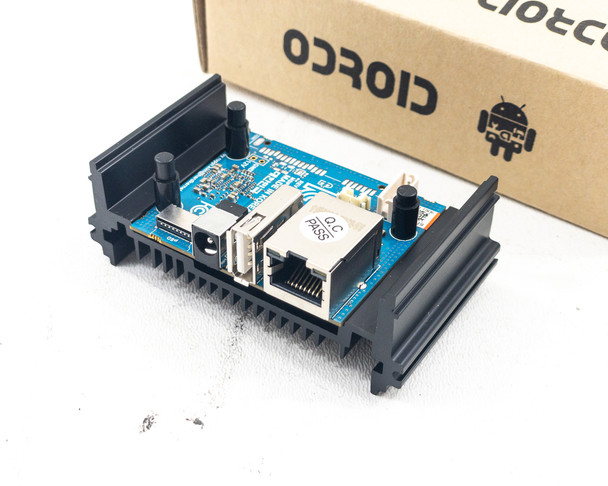 ODROID-MC1 Solo board mounted in black heatsink bracket showing Gigabit Ethernet port, USB 2.0 port, and blue PCB