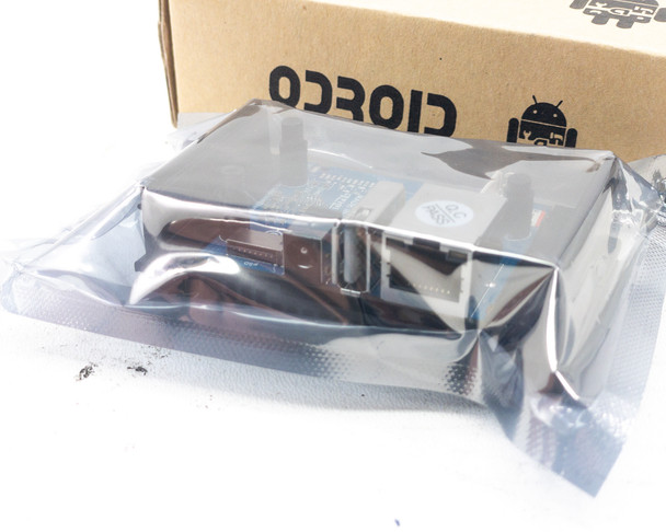 Rear view of ODROID-MC1 Solo board in antistatic bag showing heatsink fins and enclosed module assembly
