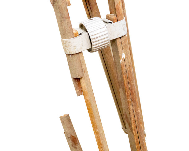Wooden leg detail showing broken leg section — leg spreader clamp and weathered wood condition visible