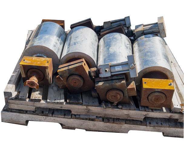 Close angle view of conveyor drum lot on pallet showing hydraulic brake blocks and galvanized drum surfaces