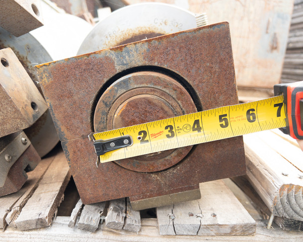 Close-up of cast iron hydraulic brake block with tape measure showing approximately 5-inch block width