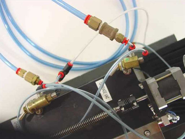 Pneumatic lines and brass fittings on the AMC Bondo4 assembly — blue tubing with push-fit and valve connectors