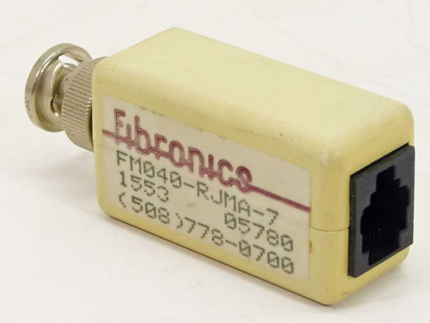 Fibronics FM040-RJMA-7 RJ11 to BNC adapter – front and side view showing Fibronics label, model number, RJ11 port, and BNC connector