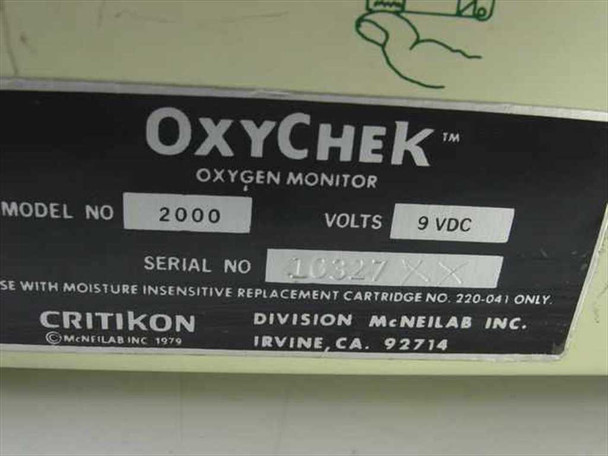 Critikon OxyChek 2000 Oxygen Monitor rating plate closeup showing Model No. 2000, Volts 9 VDC, Serial No., and Critikon Division McNeilab Inc. Irvine CA markings