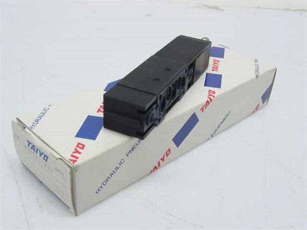 Taiyo USR540-MXF pneumatic block manifold resting on original Taiyo box — rear view showing mounting slots