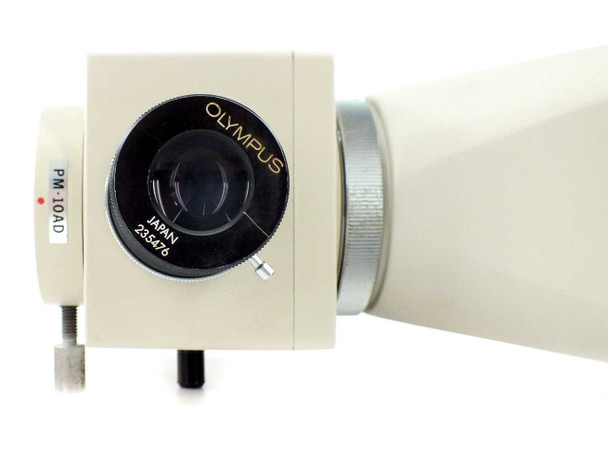 Olympus PM-10AD camera head — front close-up showing Olympus lens, Japan and serial number markings, and PM-10AD label on side