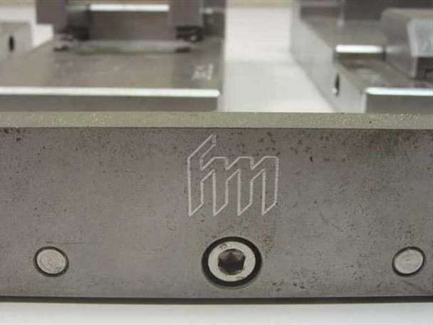 Side view of FM-branded IC test fixture jig showing engraved fm logo monogram on machined aluminum body