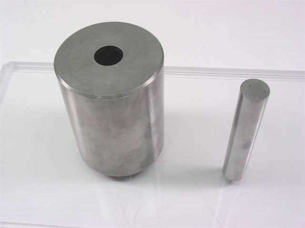 South Bay Technology sectioning saw die component — tall hollow cylindrical die body and separate steel punch rod on acrylic surface