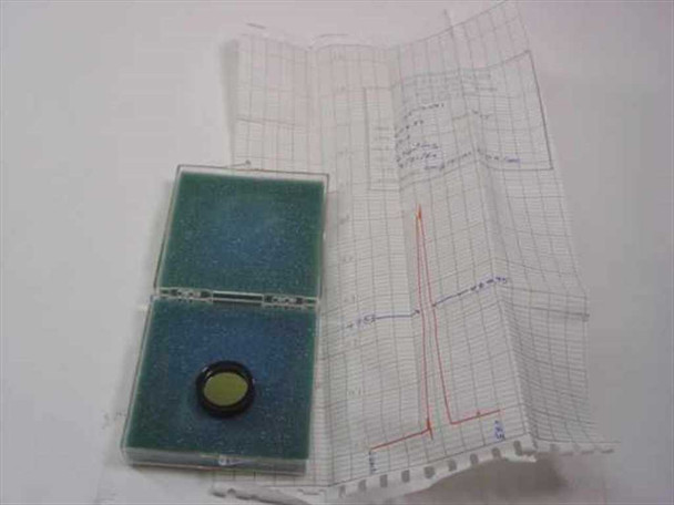 Ealing 35-3441 bandpass optical filter in open case alongside original factory spectral test chart printout
