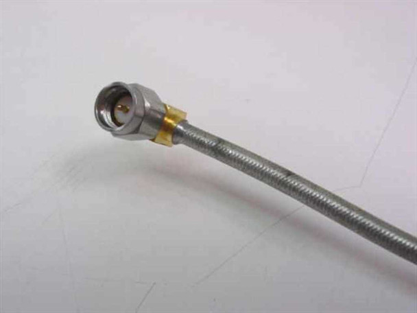 KMW 200580-001 RF cable close-up of SMA right-angle male connector end with gold body and braided stainless cable jacket