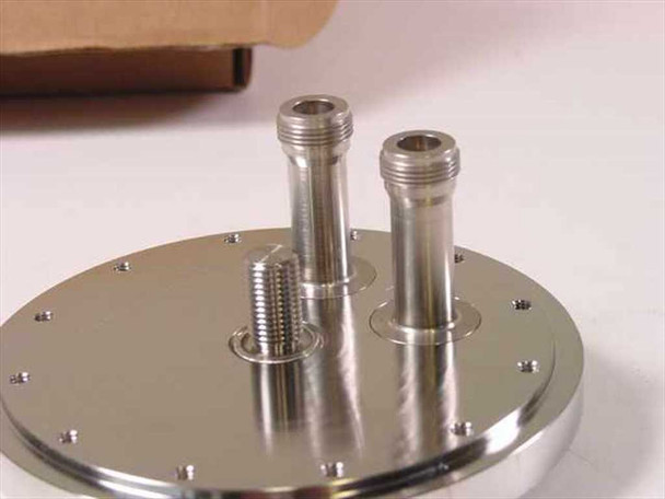 Omni Cap 101192-0027 vacuum chamber fill port lid — angled side view showing two tall threaded aluminum feedthrough standoffs and one threaded stud protruding from top surface with bolt-circle holes around edge