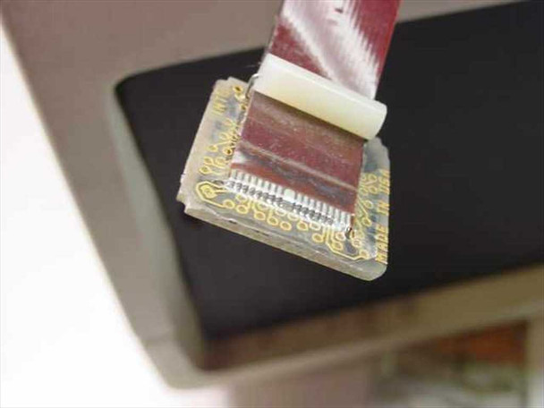 Close-up of ribbon cable flex circuit board connector end showing gold contact fingers