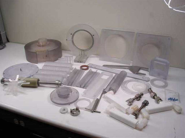 Overhead view of plastic mixer components lot including rotor, impeller disc, mixing blades, and miscellaneous fittings