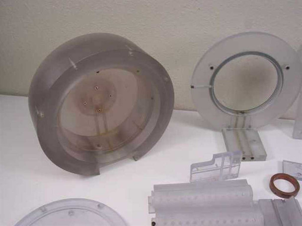 Underside view of plastic rotor bowl showing central shaft hub and interior structure; acrylic circular bracket alongside