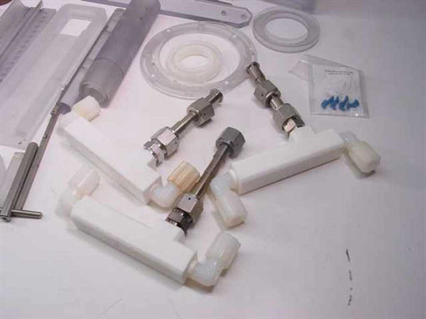 Detail of stainless steel mixer shaft fittings with hex nuts, nylon body blocks, plastic impeller disc, and blue hardware bag