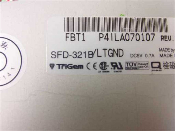 TriGem SFD-321B/LTGND floppy drive bottom label showing model number, DC 5V 0.7A power rating, FBT1 and P4ILA070107 part numbers, and CE/UL/TUV certifications