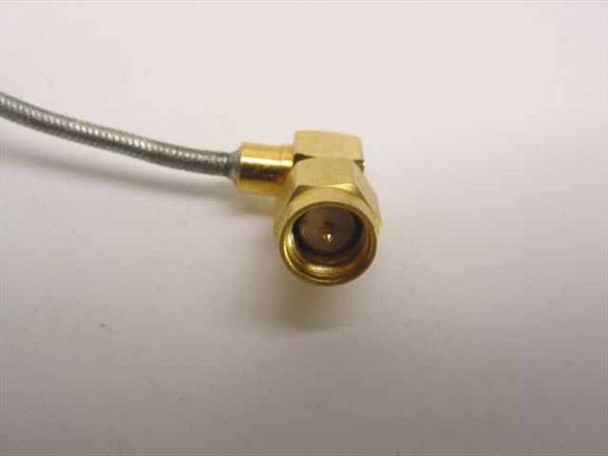Close-up of right-angle SMA-Male connector on semi-rigid flexible coaxial cable showing gold-plated brass body and center pin
