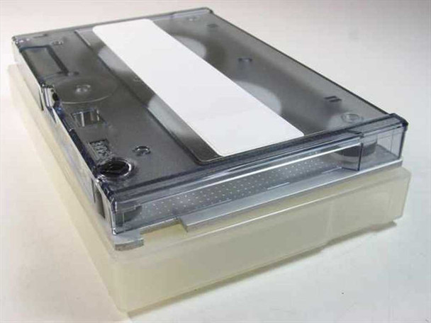 Unbranded 1/4-inch QIC data cartridge tape 450 ft — angled top view showing clear plastic shell with white label area, seated in protective plastic storage case