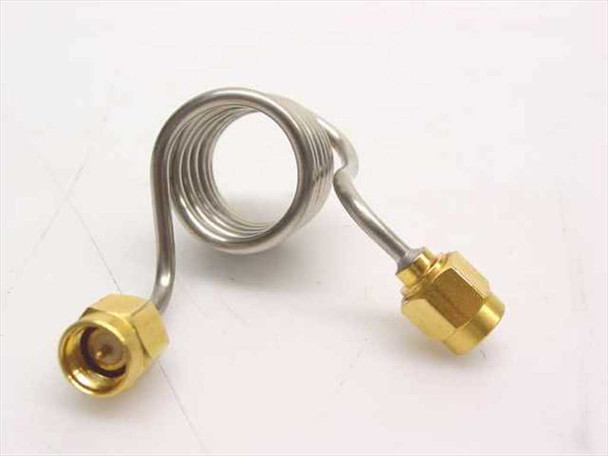 Unbranded stainless steel coiled coaxial cable with SMA male connectors on both ends – side view showing full coil and both gold connectors