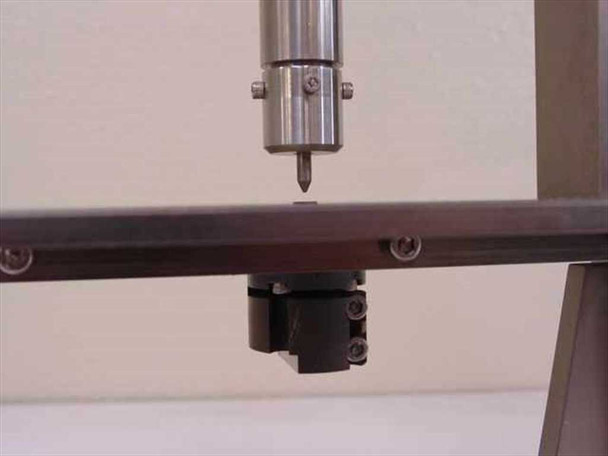 Close-up of dial indicator spindle mount clamp and probe tip holder on the measurement fixture column