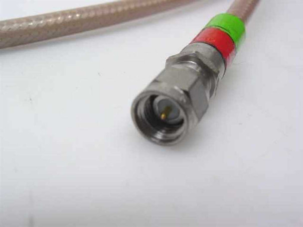 Close-up of SMA male connector end of RG-400/U coaxial cable with green and red color-coded bands on silver-braided jacket