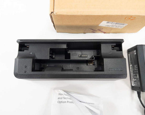 Compaq PP1003A battery charger dock — top-down view showing dual battery bay slots and multi-pin connector contacts