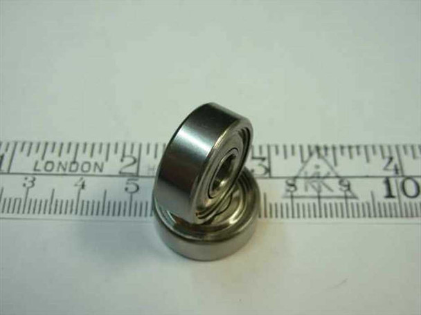 Side profile view of stainless steel shielded miniature ball bearing showing width and shield detail next to ruler