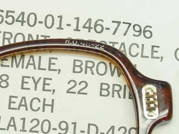 Close-up of USS 6540-01-146-7796 spectacle front bridge showing R.O. 48-22 molded marking and three-barrel hinge detail
