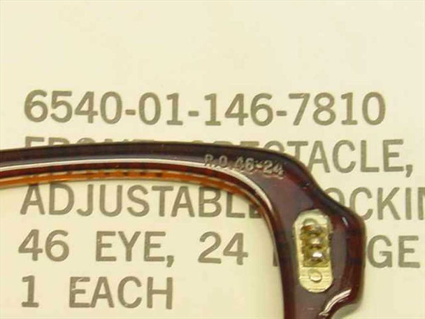 Close-up of military spectacle frame temple hinge and size marking RO 46-24 stamped on brown cellulose acetate frame