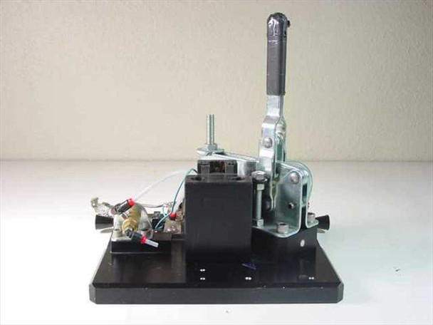 Custom vacuum chuck assembly rear-left view showing pneumatic block, spanner switch connections, braided ground wire, and aluminum base