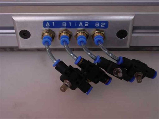 Close-up of pneumatic push-to-connect fittings on aluminum rail labeled A1, B1, A2, B2 with blue fittings and tubing