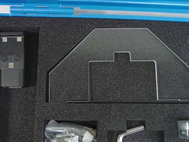 Close-up of foam insert upper section showing acrylic alignment template, hex key, and hardware bag in cutouts