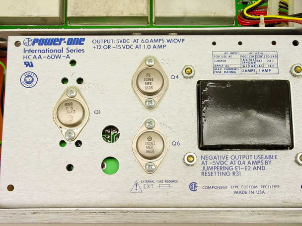 ComStream CM101 internal Power-One HCAA-60W-A power supply close-up — output specs label showing 5VDC/6A and +12/+15VDC/1A, transistors Q1 Q4 Q6